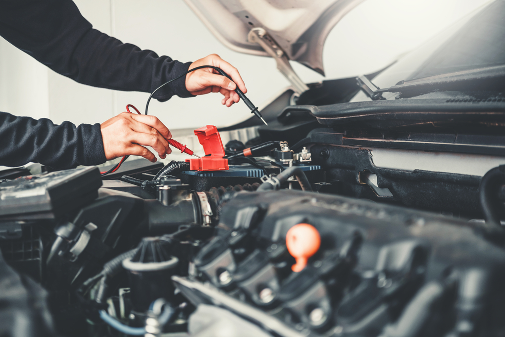 Car mechanic performing some electronic tests