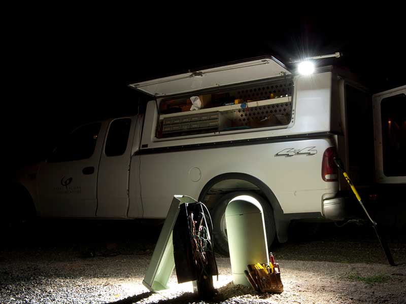 A white van with a light on top, parked on a street.