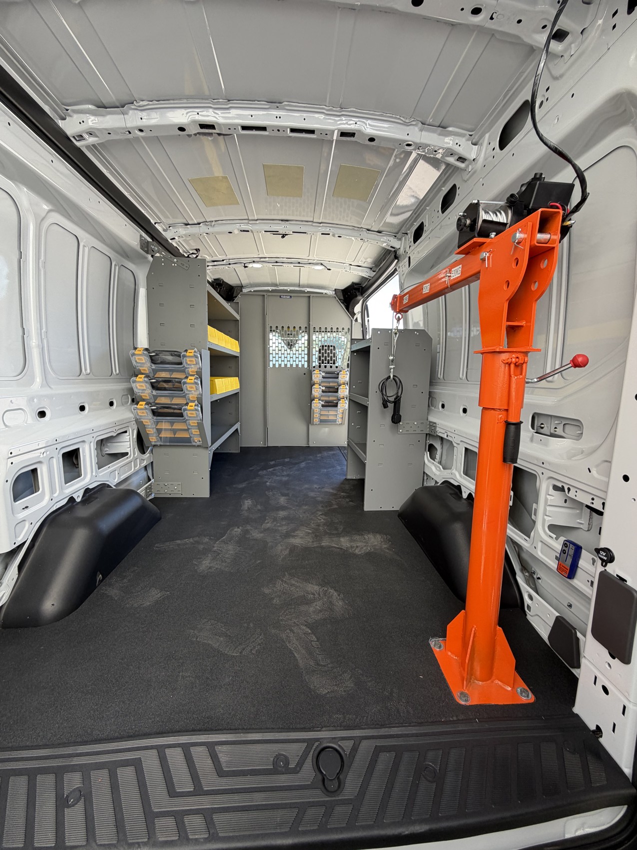 Rear interior of Atlas Butler’s plumbing van showing the mounted crane, shelving and yellow bins