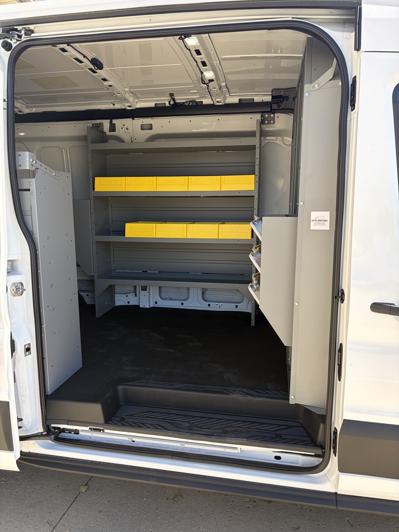 Side-door view of the shelving, yellow bins and partition in Atlas Butler’s van